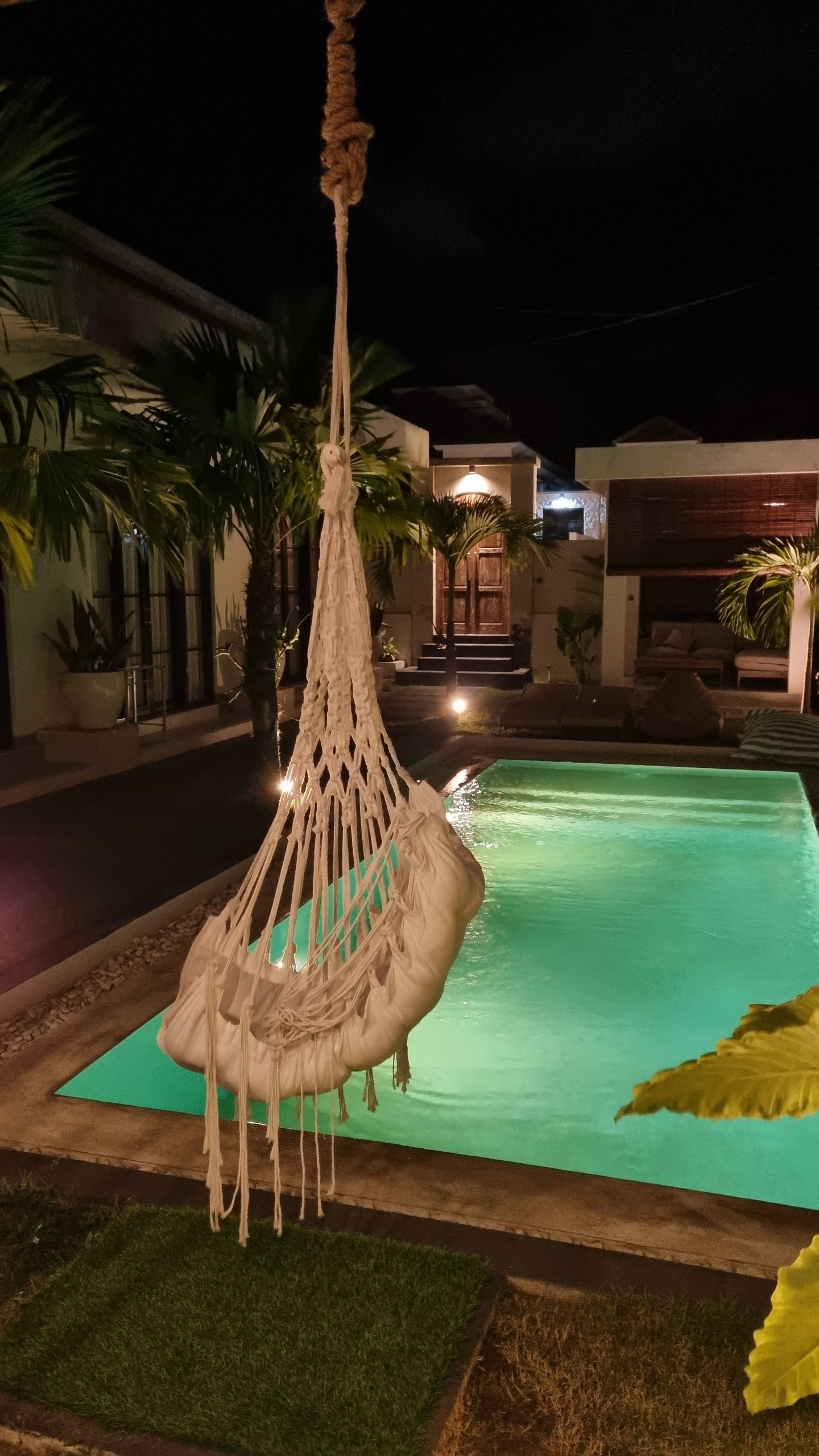 Hammock chair beside the glowing pool at night