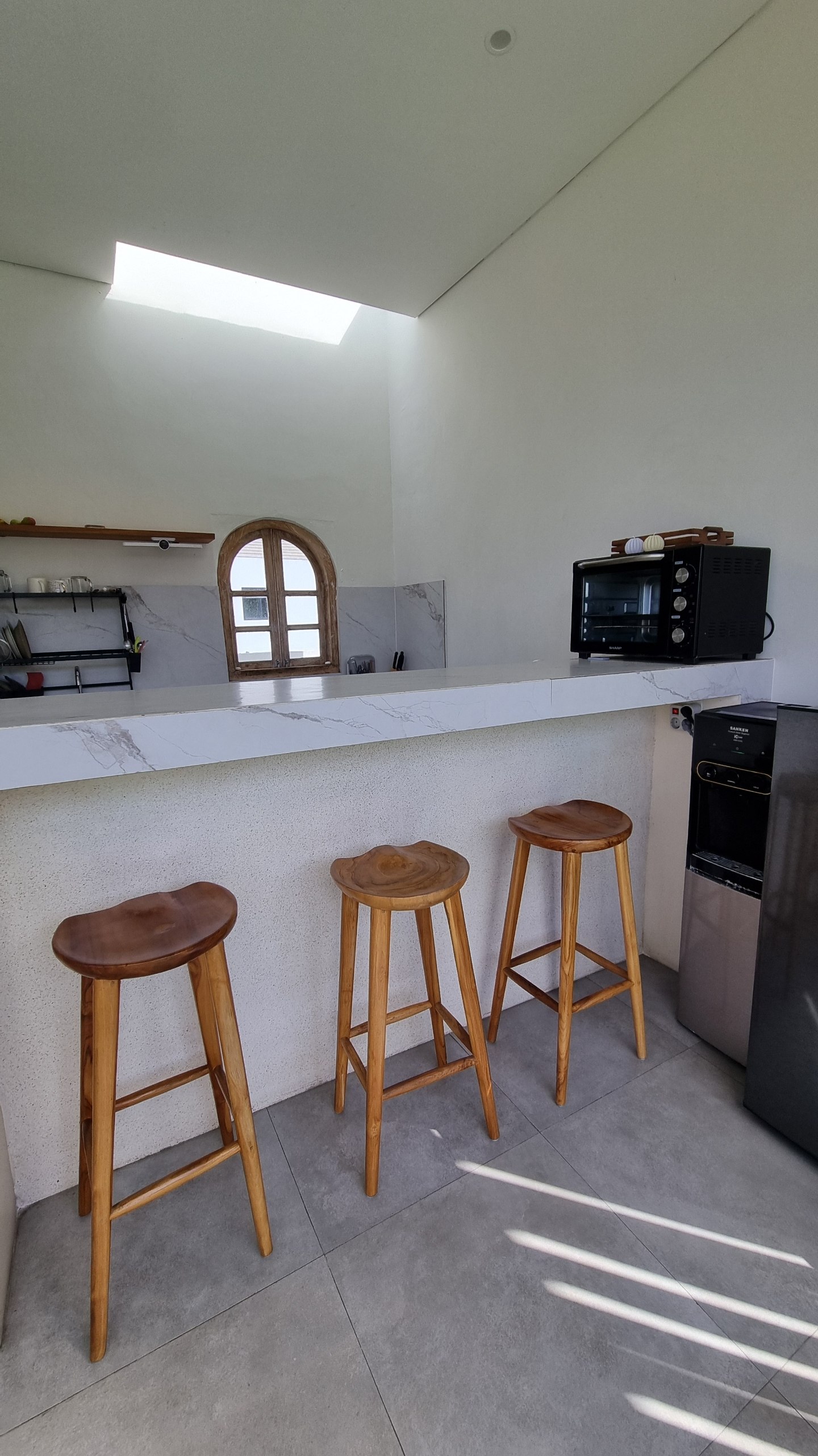 Three teak stools at the marble kitchen bar