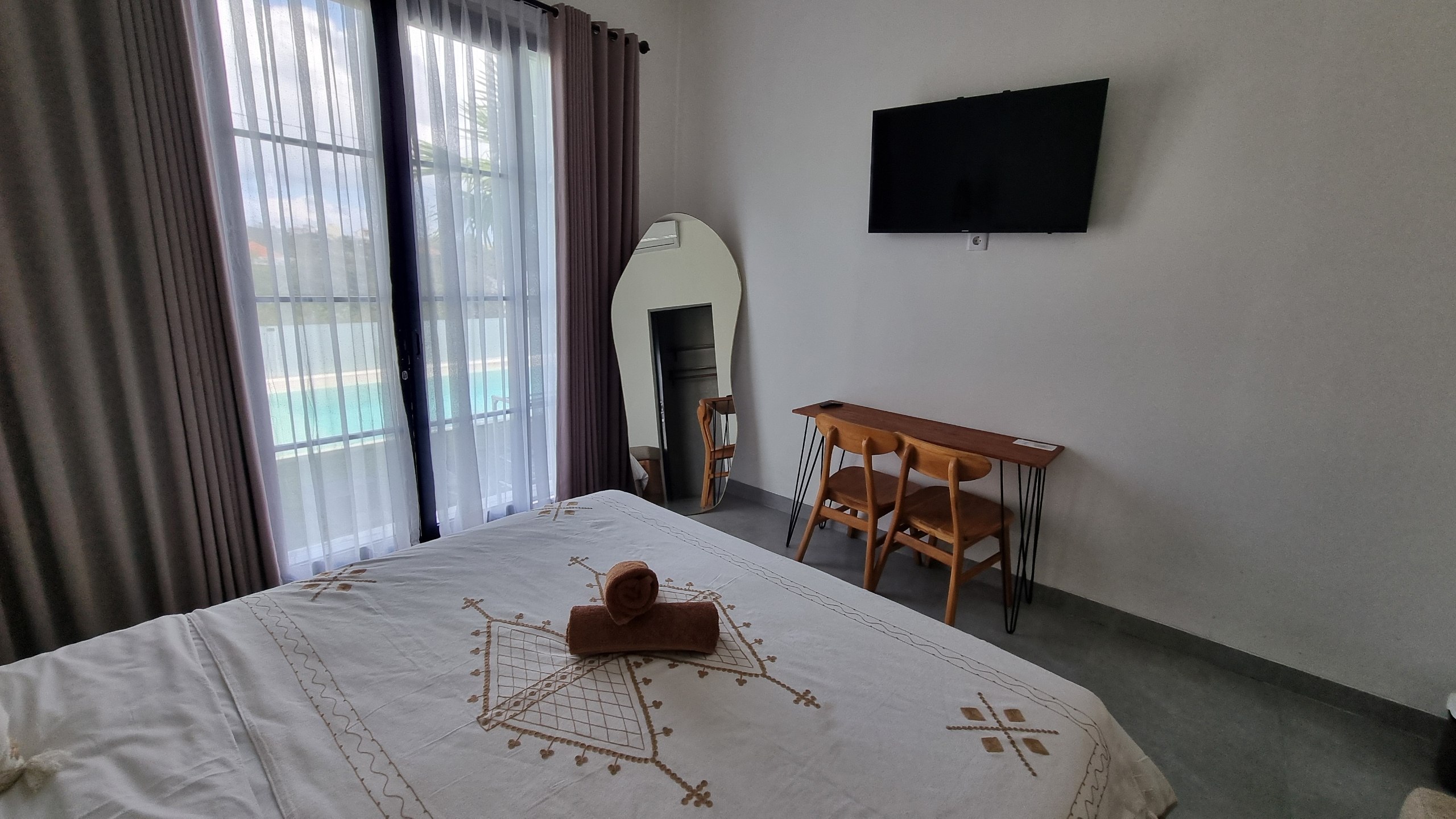 Bedroom with a double bed, wall-mounted TV and work desk