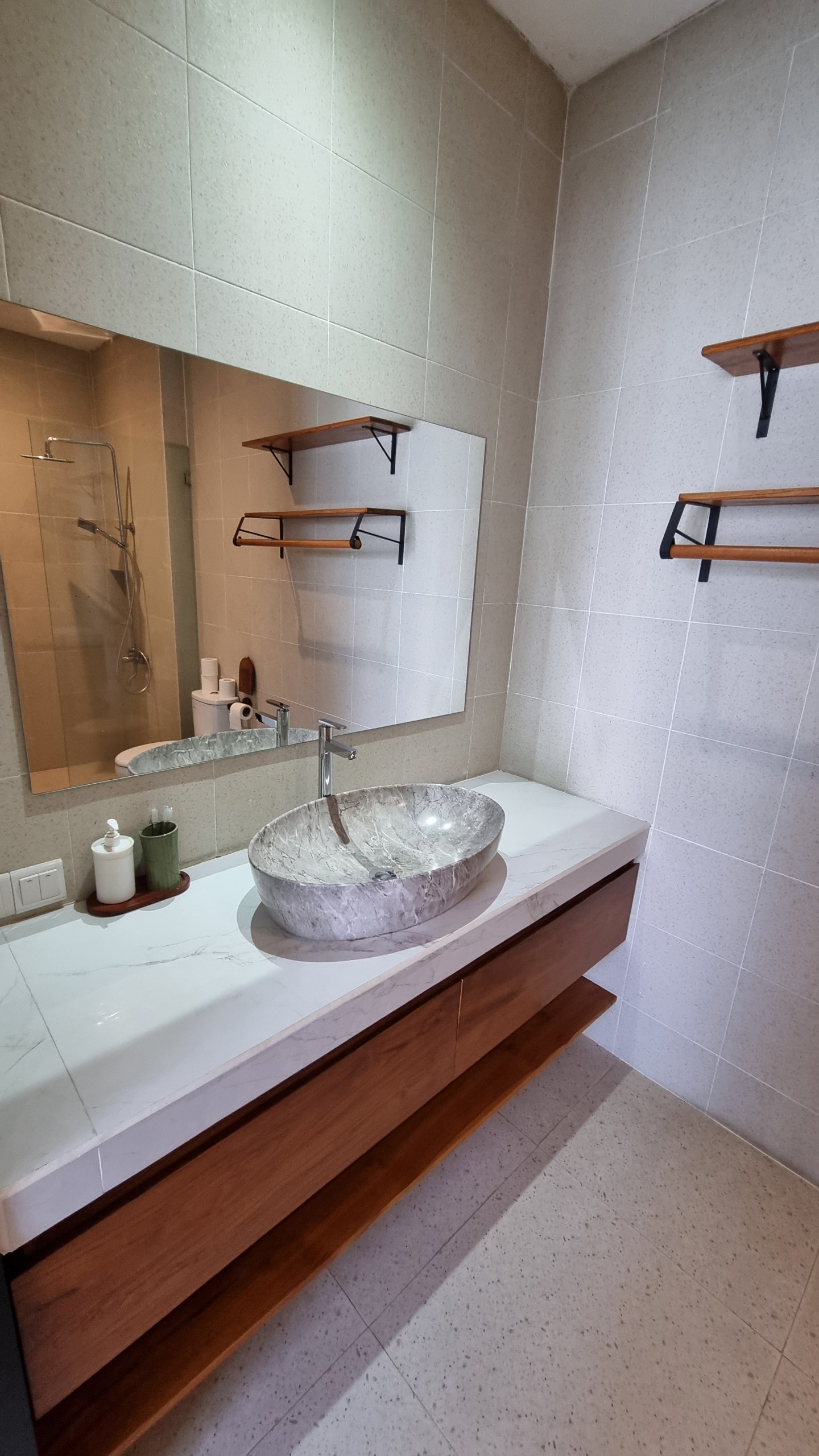 Bathroom vanity with a stone basin and floating teak cabinet